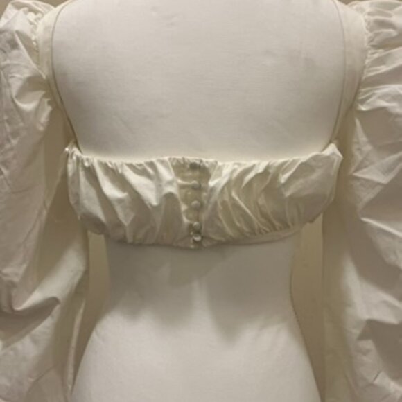A white crop top with a low neck line, a central bonding detail for structure. - Picture 2 of 3